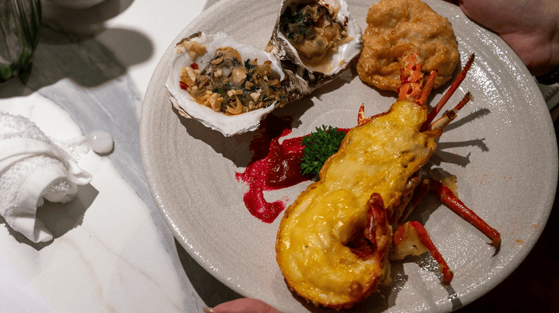 Guests can enjoy a curated Ha Long seafood experience, including Ha Long squid cake and baked lobster with cheese